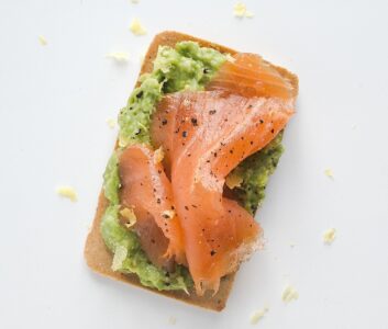 Quick gluten-free appetizer featuring avocado and peas with smoked salmon